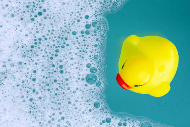 istock Yellow rubber duck in water with soap foam 2158549131