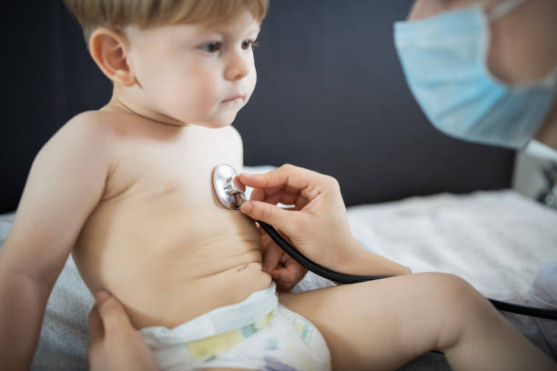 istock Doctor examining little patient at home visitation. 2158549679