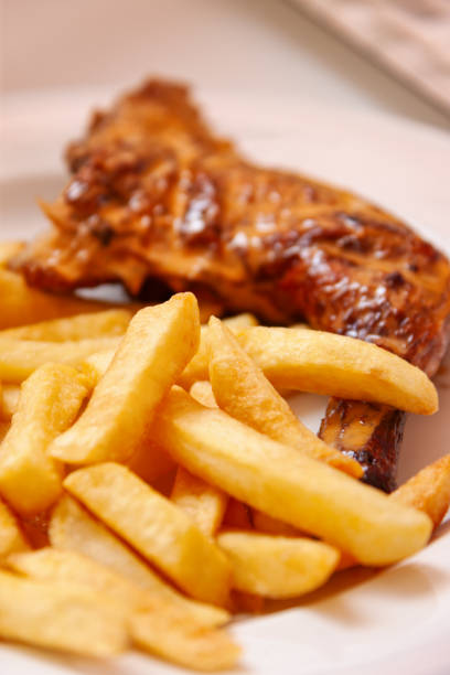 istock potato chips fried and chicken leg in a plate 2158553945