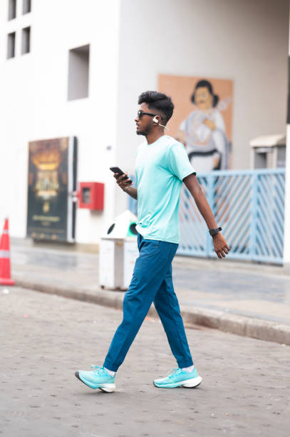 istock Focused young man using smartphone on city street 2158555117