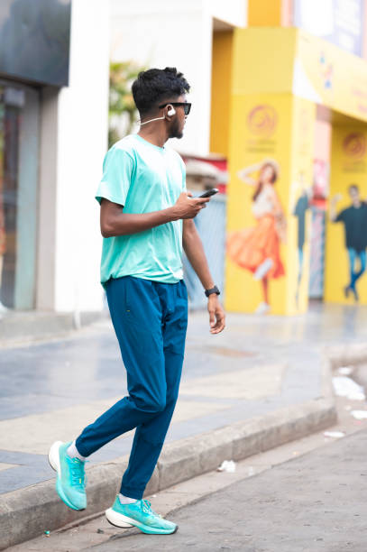 istock Focused young man using smartphone on city street 2158555144