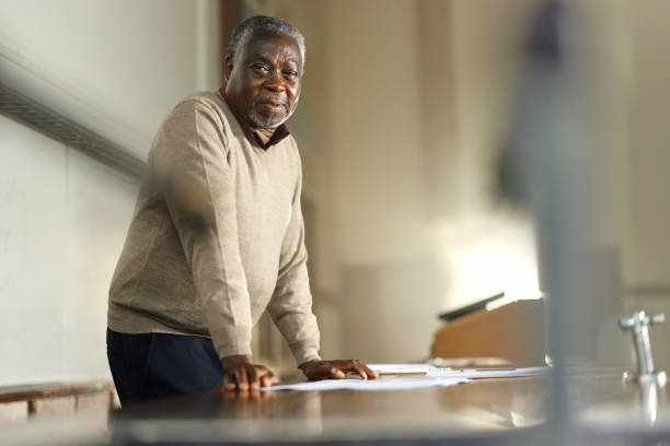 Black male professor standing in lecture hall. Copy space.