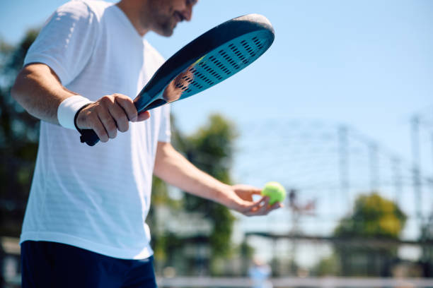 istock Close up of  athletic man serving the ball while playing paddle tennis. 2158557005
