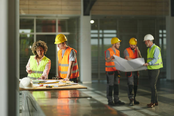 istock Inspectors working on plans with manual workers in construction building. 2158557836