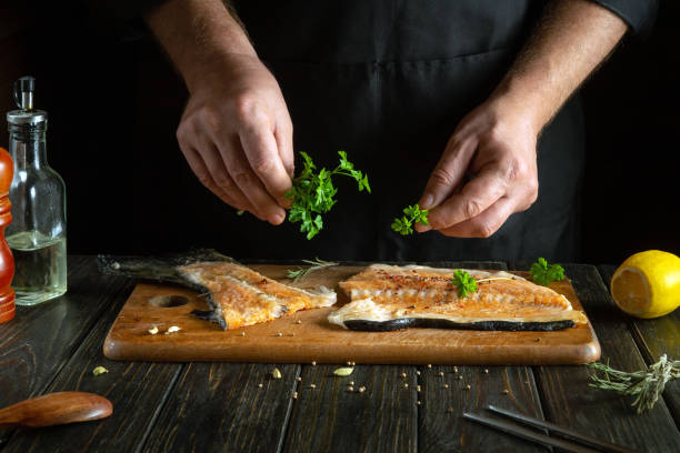 istock The chef prepares fresh red fish on the kitchen table in the hotel. Before frying, fish steaks are seasoned with aromatic herbs. Asian cuisine. 2158558996