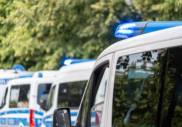 Germany, Berlin, Berlin Central, June 07, 2024 - Police cars with blue flash light against trees