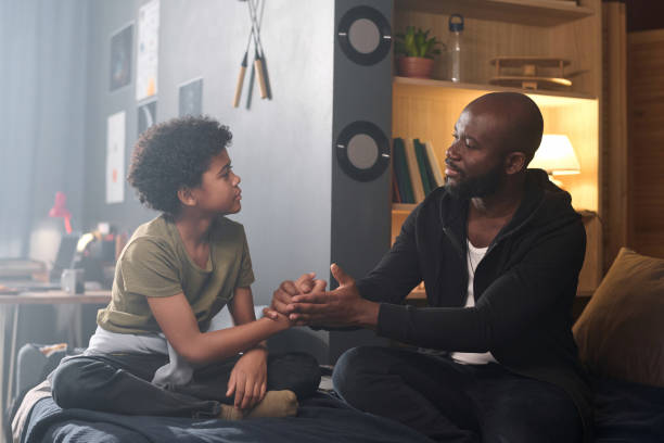 istock Loving Parent Talking to Son and Holding Hands 2158561483