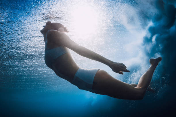 istock Woman in bikini dive without surfboard underwater with ocean wave. 2158564770