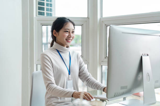 istock Young business Professional Woman Working on Computer in Modern Office with Large Windows and Natural Light 2158564844