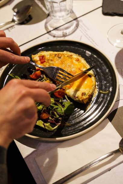 istock Person eating scrambled eggs with salad and tomato 2158566077