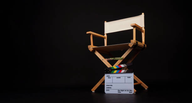 istock White director chair with clapper board and megaphone on black background. 2158569427