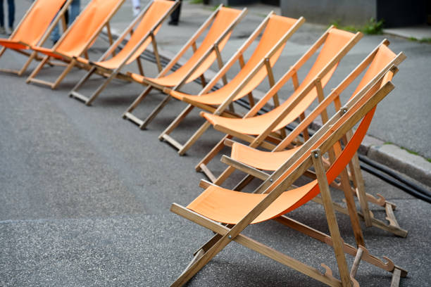 Tired sun loungers stand on the beach at sunset, waiting to relax.