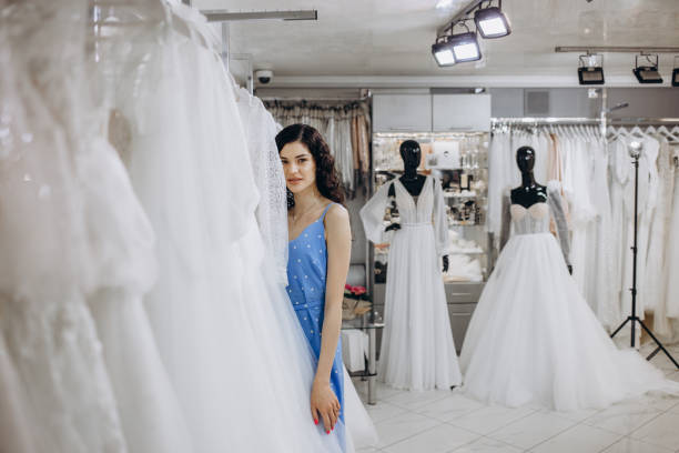 istock Attractive bride choosing a wedding dress in the store 2158572451