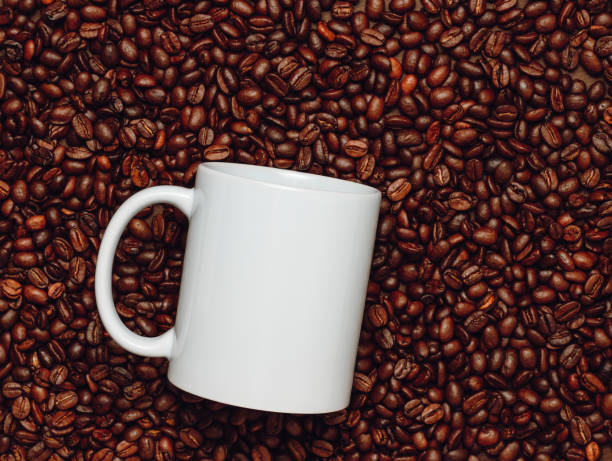 istock White mockup mug on coffee beans, top view. 2158572753