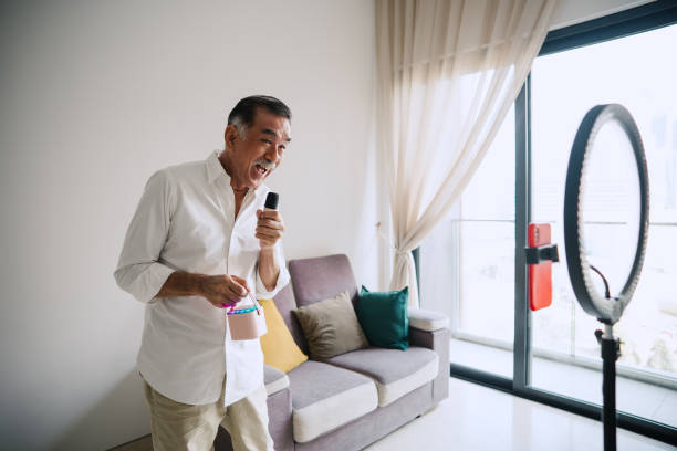 istock Asian elderly man singing with a microphone and live streaming. 2158573024