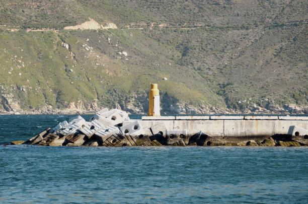 istock a small pier with a lighthouse in front of a mountain range 2158573428