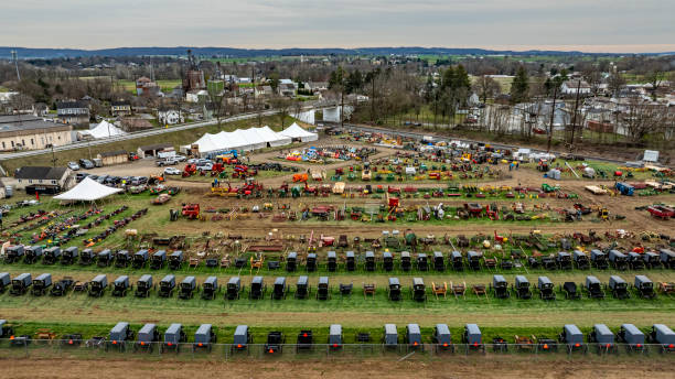 Gordonville, Pennsylvania, USA, March 3, 2024 - A bustling rural auction comes to life in this overhead shot, capturing rows of Amish buggies and an array of agricultural equipment on sale.