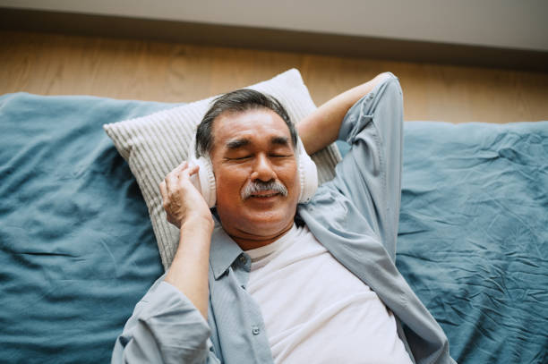 istock Mature man relaxing with music on the bed. 2158575309