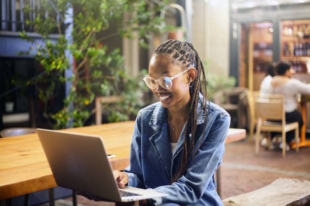 istock Smiling and Typing: Young Woman's Productive Moment at a Cafe 2158577319