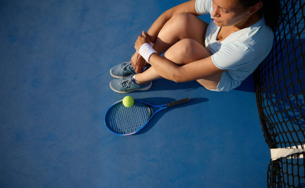 istock Tired tennis player resting on court by the net 2158578378