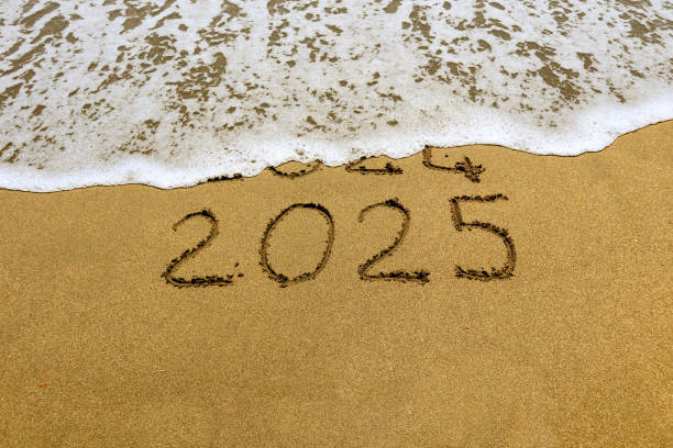 istock New year 2025 and 2024 on sandy beach with waves 2158590740