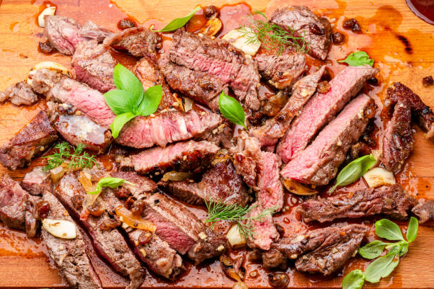istock Sliced juicy medium rib eye steak on wooden board. Top view. 2158593250