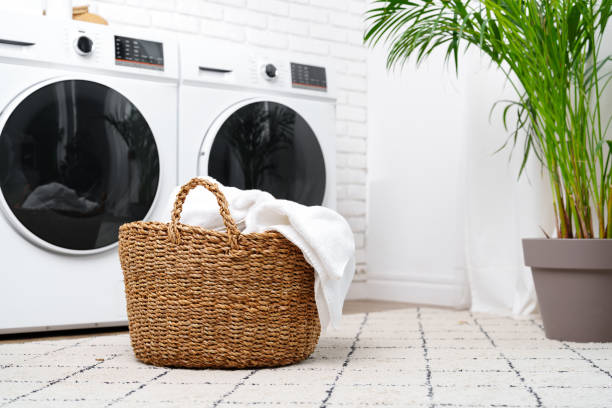 istock Laundry Basket With White Towels Near Modern Washers In A Modern Home 2158595333