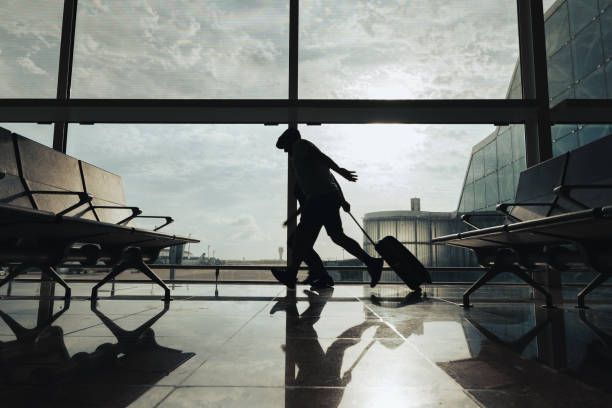 istock Couple of passengers run through the airport to avoid missing the flight. 2158597756