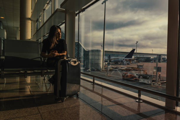 istock A woman waits for her flight while looking out the airport window. 2158597855