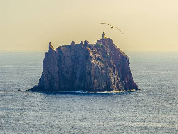 Strombolicchio, Stromboli, Aeolian Islands, Sicily, Italy:\nView of Strombolicchio from Stromboli at dawn