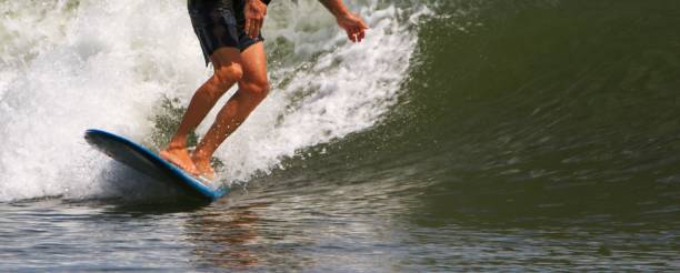 istock Close up of a man wearing black clothes while surfing 2158603298