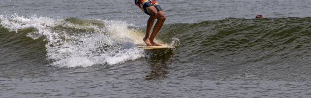 istock Man moving up on his surfboard while surfing at Gilgo Beach 2158603325