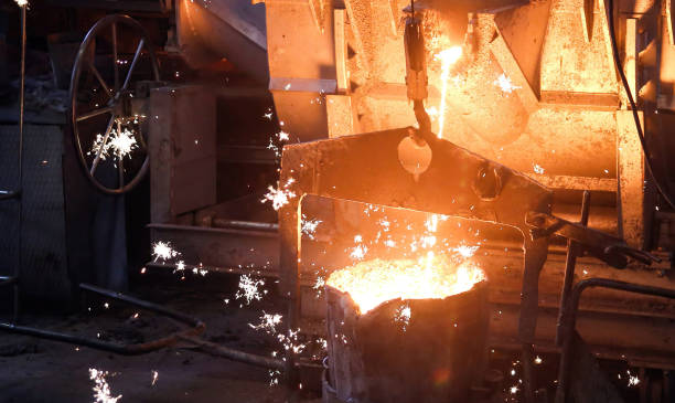 istock Molten metal poured into mold, glowing brightly, sparks flying, isolated on black background. 2158606883