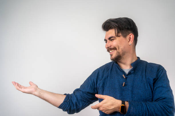 istock Happy man pointing into a blank copy space spot with two hands. 2158612226