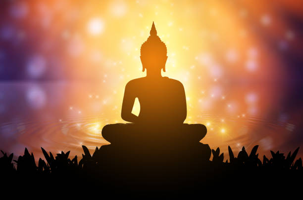 Buddha statue Silhouette Buddha sitting on lotus flower on orange background