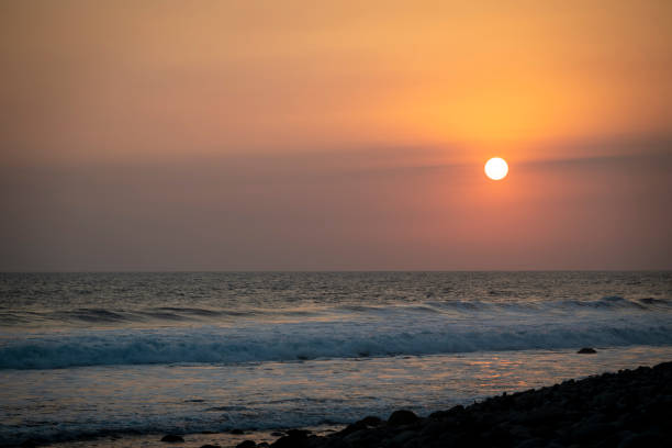 Person walking on a rock during a sunset in Puerto Escondido, Oaxaca, Mexico.