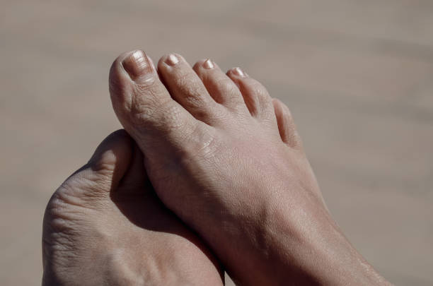 Close-up of two feet on the beach