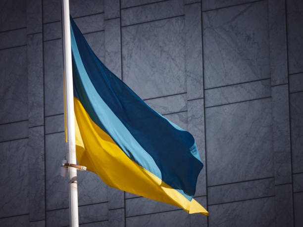 istock Low angle view of flag waving against building 2158619264