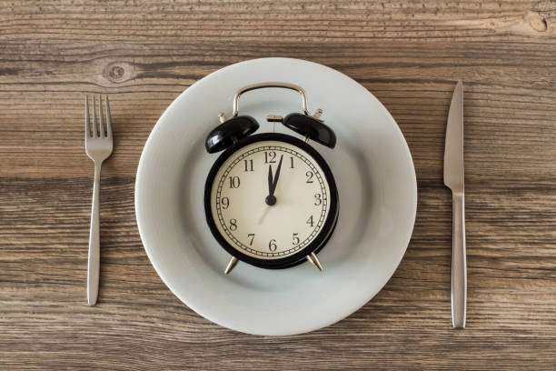istock Vintage alarm clock in white porcelain plate with cutlery 2158623091