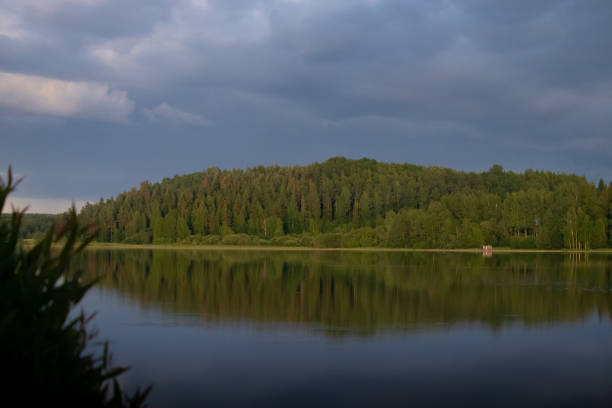 Midsummer view of a still Nordic lake before the storm.