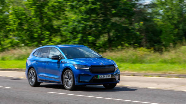 Milton Keynes,UK - June 21st 2024: 2024 blue Skoda Enyaq 85 sportline electric  car driving on a British country road