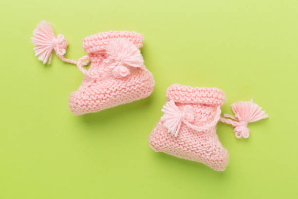 istock Pink baby booties on color background, top view 2158628112