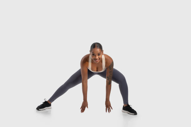 istock African American Woman Performing a Squat on White Background 2158629730