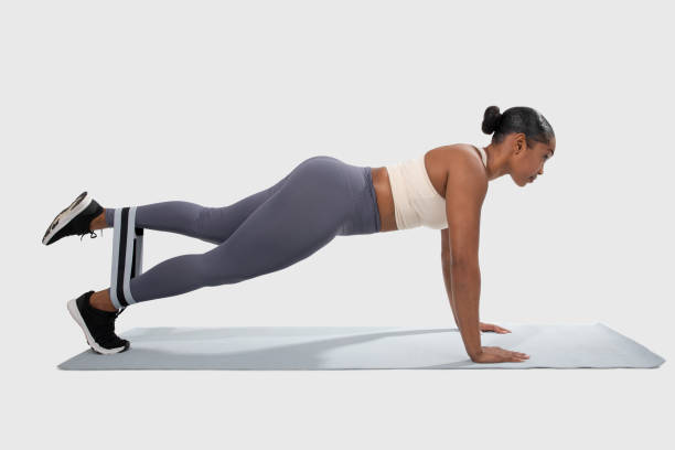 istock Woman Doing Push-Ups on Mat, Using Resistance Band 2158629735