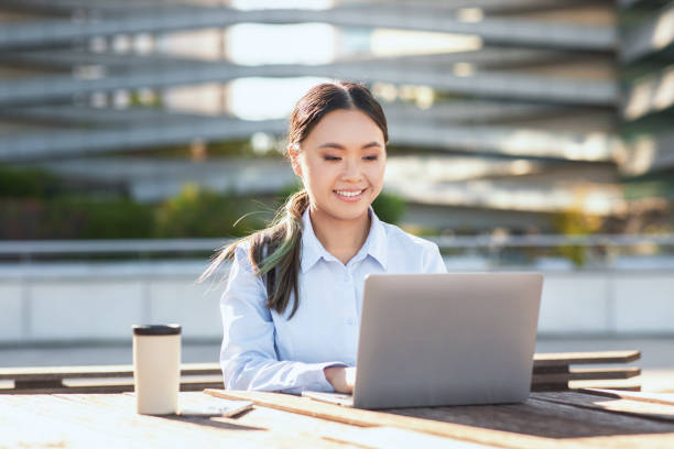 istock Young Asian Woman Using Laptop at Table 2158629808