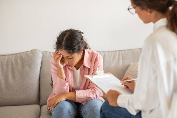 istock Concerned Young Woman Consults With Professional Therapist in Office Setting 2158629904