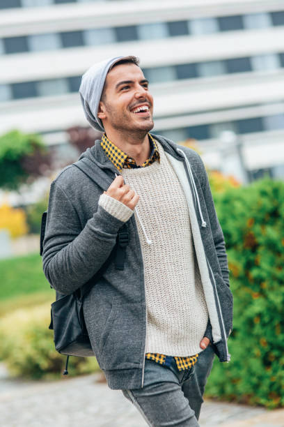 Portrait of smiling young man outdoor in the city. Man looking happy and walking on the city street