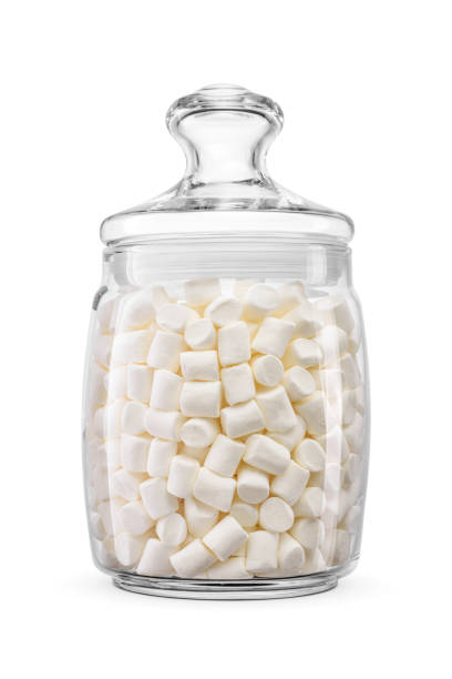 Clear glass jar of small sweet tasty marshmallows isolated on white.