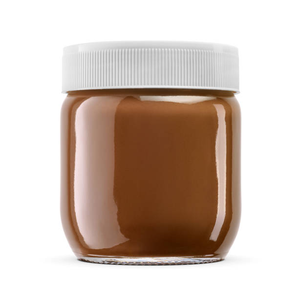 istock Brown hazelnut chocolate spread in clear glass jar isolated on white. 2158634436