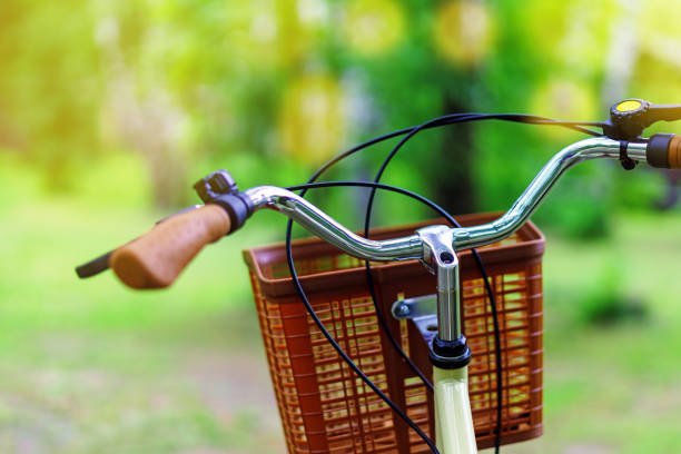 istock Bicycle handlebar with a basket, poised for a leisurely ride, against a blurred green backdrop of trees 2158638501